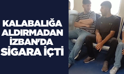 Kalabalığa aldırmadan İZBAN'da sigara içti